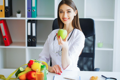 smiling female doctor holding apple